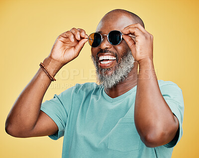 Buy stock photo Black man, fashion and happy with sunglasses in studio for trendy style, designer eyewear and summer ready. Mature person, laughing and edgy accessory for aesthetic or confidence on yellow background