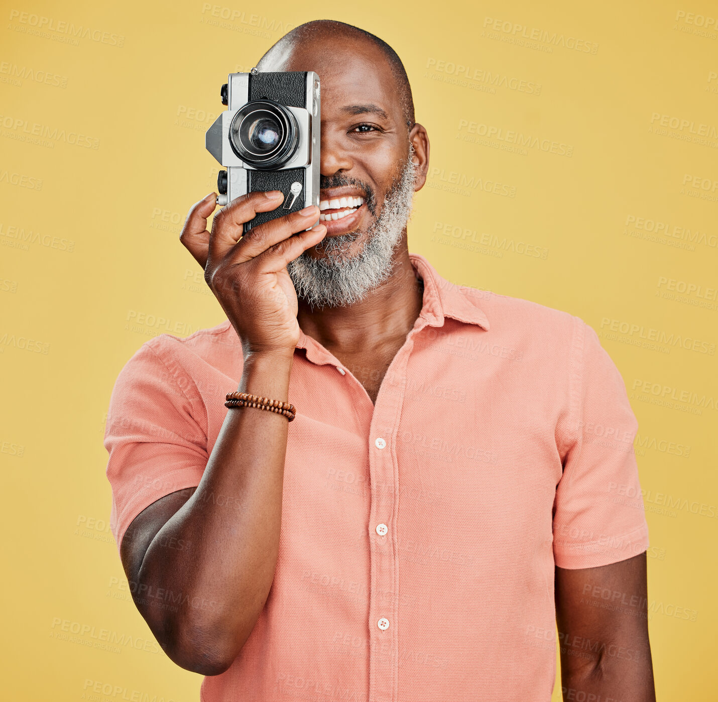 Buy stock photo Portrait, black man and camera in studio for photography, taking picture and smile for aesthetic. Mature journalist, tech and happy on yellow background for website update, image source and hobby