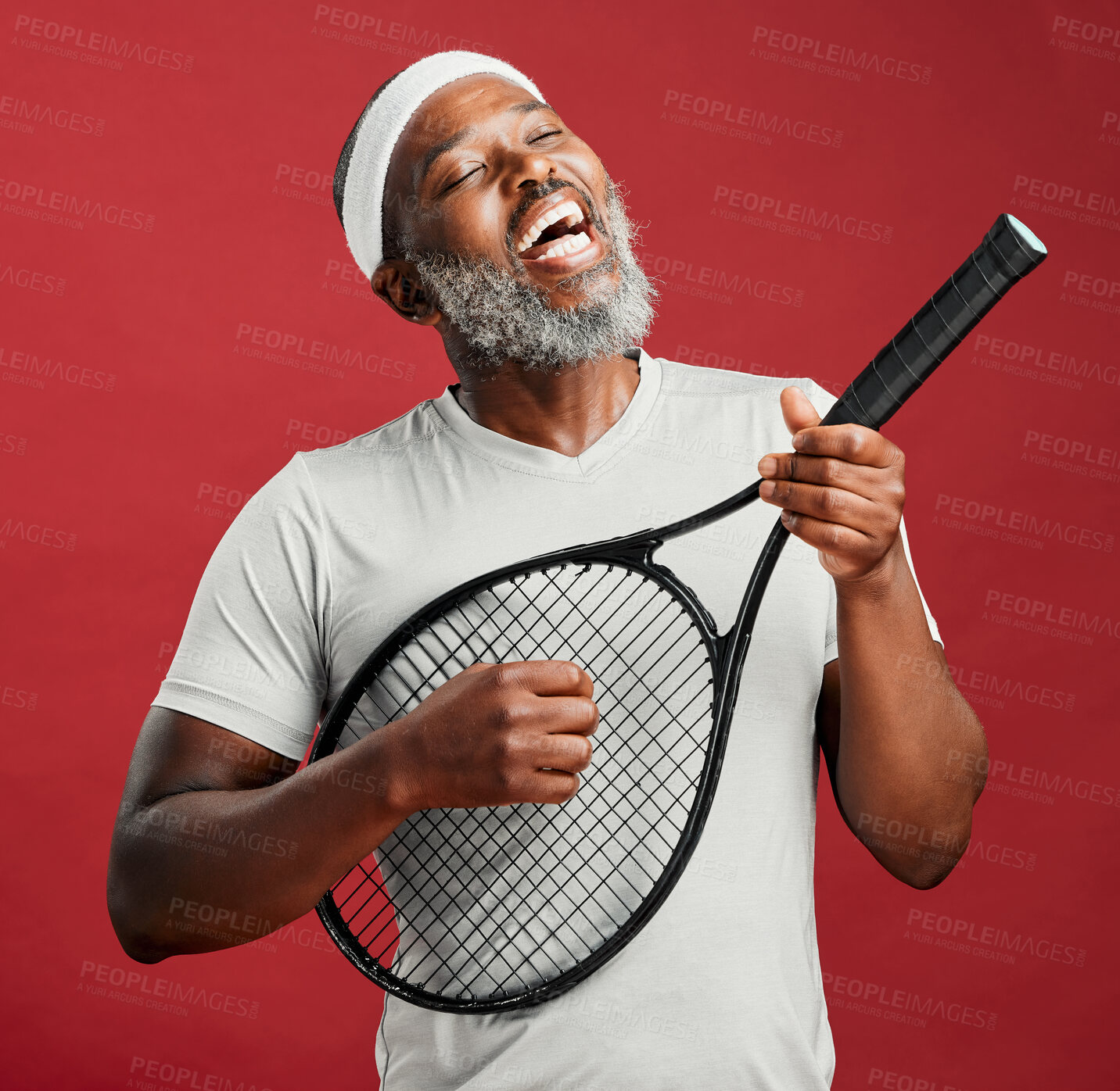 Buy stock photo Happy, fitness and black man with racket, studio and silly with equipment for tennis, fun and goofy. Red background, playing and fake guitar for mature person, athlete and workout for wellness