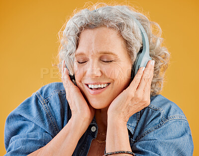 Buy stock photo Mature woman, headphones and relax in studio, hearing audio and streaming radio on yellow background. Female person, listening and calm podcast for peace, technology and online for classical playlist