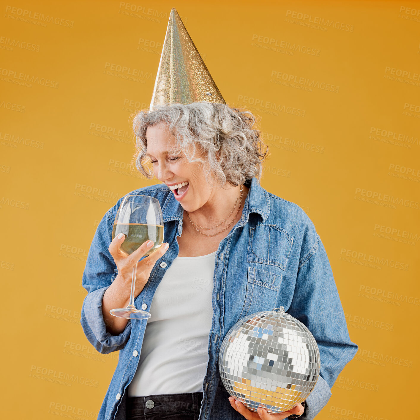 Buy stock photo Studio, mature woman and party with wine for alcohol beverage, drinking and excited for celebration. Female person, screaming and enjoy with hat for new year, event or disco ball by yellow background