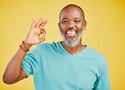 Buy stock photo Black man, portrait and okay sign in studio, perfect symbol and agreement on yellow background. Mature person, emoji and approval for feedback in review, opinion and icon for thank you or support