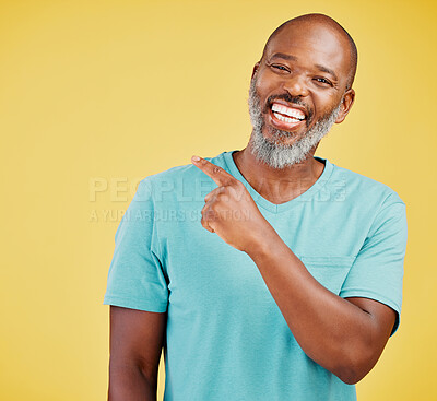 Buy stock photo Black man, happy and pointing in studio with portrait, offer or promotion selection. Mature person, smile or show gesture on yellow background space for deal, opinion or vote decision or announcement