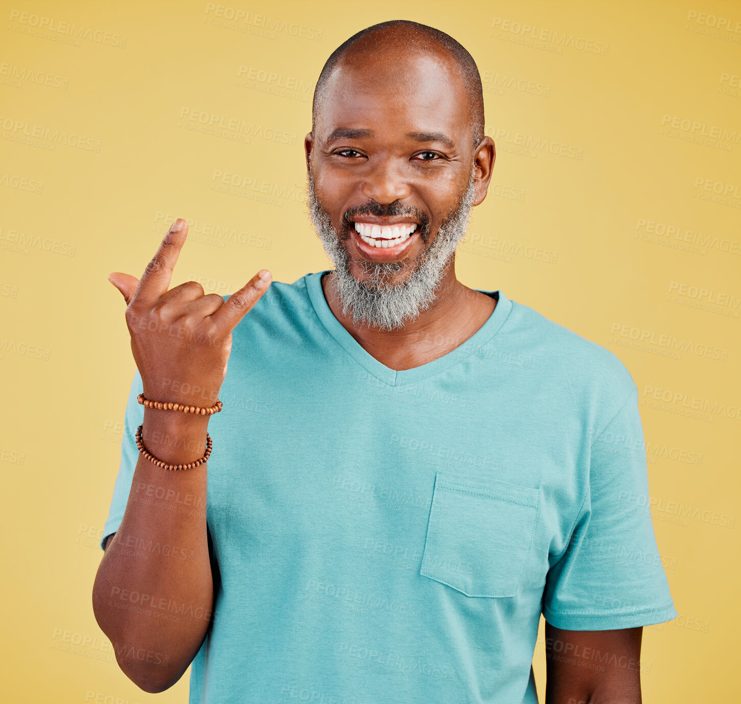 Buy stock photo Horns hand gesture, portrait and mature black man in studio isolated on yellow background for celebration. Face, rock n roll and smile of happy senior person with emoji for expression or grunge