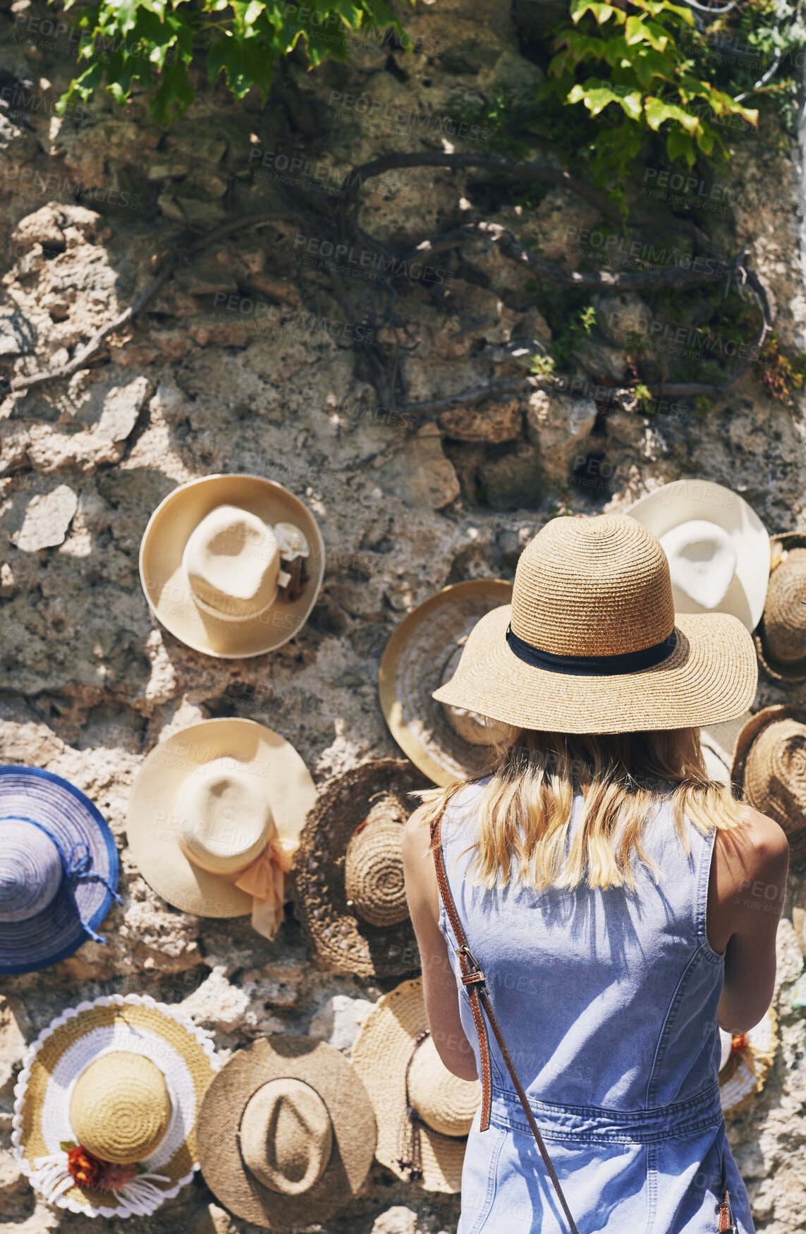 Buy stock photo Woman, back and shopping for hat at street market in summer, outdoor and search for deal on vacation. Person, customer and choice in village with fashion, clothes and discount on road in Italy