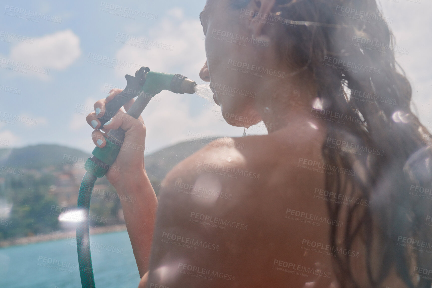 Buy stock photo Travel, woman and water from hose on boat for cleaning body, hygiene and shower splash for swimming. Girl, person and low angle with washing face on holiday cruise for adventure and summer vacation