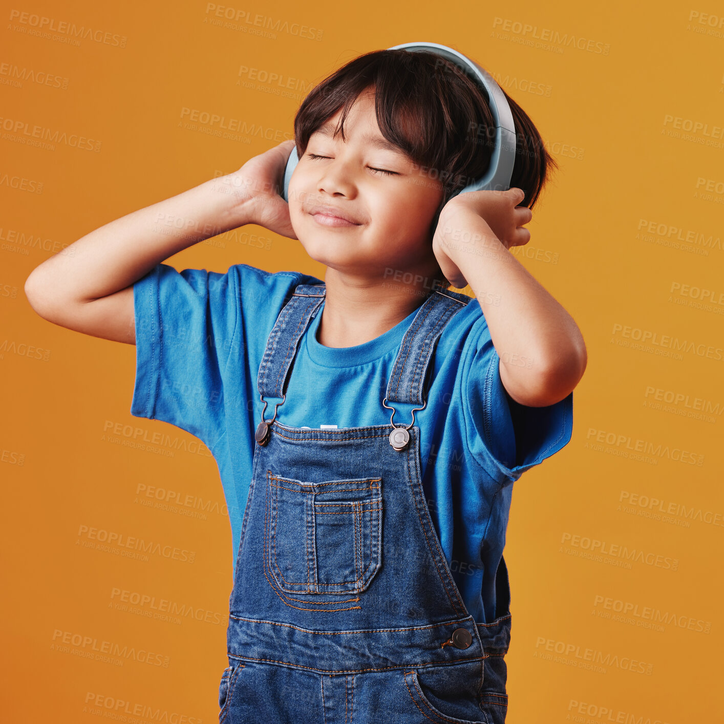 Buy stock photo Asian boy, kid and headphones with sound, listening to music and happiness on yellow studio background. Live streaming, radio and model with headset, audio and calm with tech, child and wellness