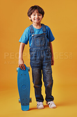 Buy stock photo Japanese boy, studio background and smile with skateboard for sports or recreation in Japan. Male person, kid and happy on portrait in confidence for fashion, style and outfit for hobby or growth