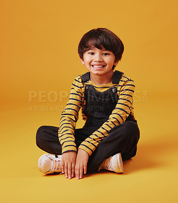 Buy stock photo Japanese boy, floor and happy in studio background for fashion with fun, outfit and swag in Japan. Male person, child and smile or satisfied on portrait in confidence with trendy clothes and style