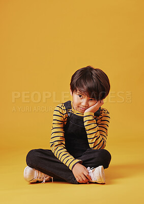 Buy stock photo Bored, lonely and thinking with Asian boy on yellow background, isolated in studio for development. ADHD, depression or sadness and child on floor with mockup space for curiosity or problem solving