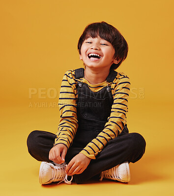 Buy stock photo Japanese boy, floor and laughing in studio background for fashion with fun, outfit and swag in Japan. Male person, happy and smile or happy on portrait in confidence with trendy clothes and style