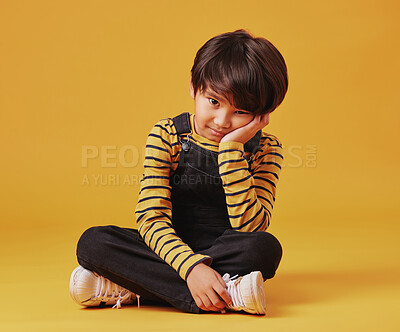 Buy stock photo Bored, lonely and portrait with Asian boy on yellow background, isolated in studio for growth. ADHD, depression or sadness and moody child on floor with mockup space for emotional development