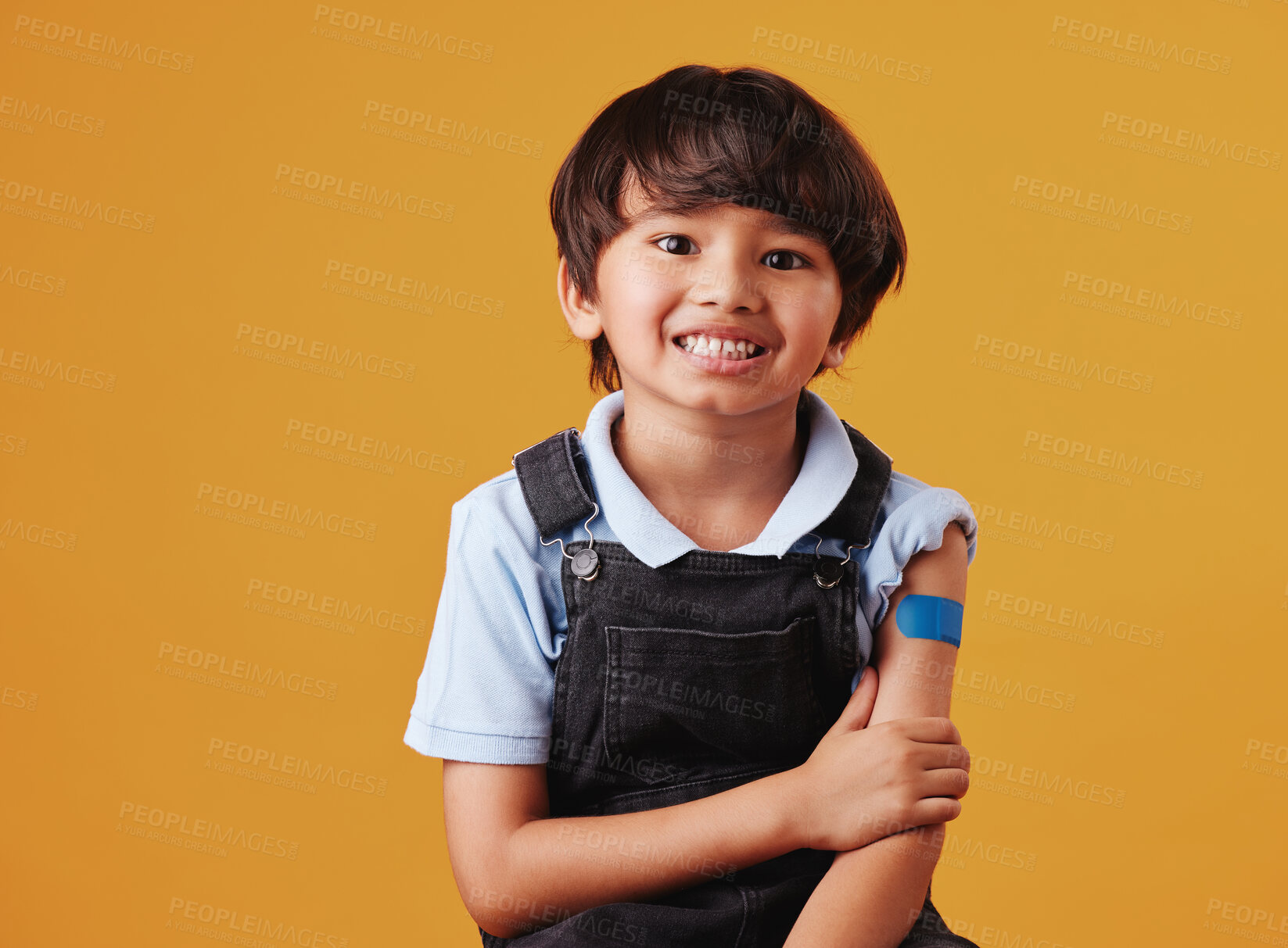 Buy stock photo Asian child, portrait and happy on studio background for vaccine, healthcare and illness prevention. Japanese boy, smile and plaster on arm for flu shot, immune system strength and first aid help