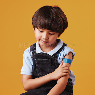 Buy stock photo Child, thinking and plaster on studio background for vaccine, healthcare and illness prevention. Japanese boy, anxiety and bandage on arm for flu shot, immune system strength and first aid help