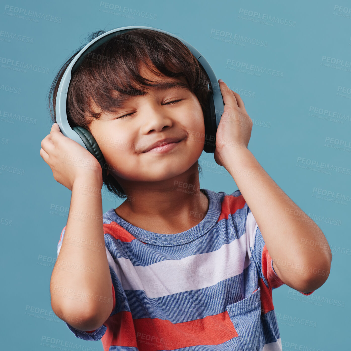 Buy stock photo Asian boy, kid and headphones with audio, listening to music and happiness on blue studio background. Live streaming, radio and model with headset, sound and calm with child, adhd and wellness