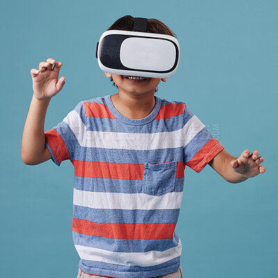 Buy stock photo Boy, vr headset and playing games in studio, streaming online and cyber interaction. Male person, entertainment and goggles for virtual world, blue background and connection for user experience