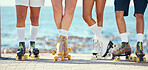 Roller skates, friends and beach with a group of people on the promenade at the beach with the sea in the background. Summer, fun and lifestyle with a skaters skating outside during a sunny day