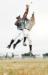 Sports, baseball and men jump to catch ball on field during game, action and motion with teamwork. Fitness, baseball team and black man jumping with teammate to help with catching for strike out.