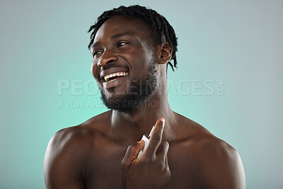 Buy stock photo Thinking, cologne and blue background with a model black man posing shirtless in studio for body spray. Perfume, product or skin with a handsome, muscular and young male standing topless on space