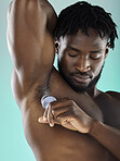 Odor, hygiene and black man with armpit deodorant isolated on a blue background in studio. Skincare, cleaning and African model with a product for body treatment and morning routine on a backdrop