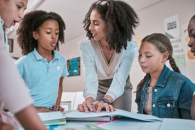 Buy stock photo Female teacher asking student a question, children learning in classroom and sign homework in book. School for teaching, educator reading kids notebook and group working together for assessment