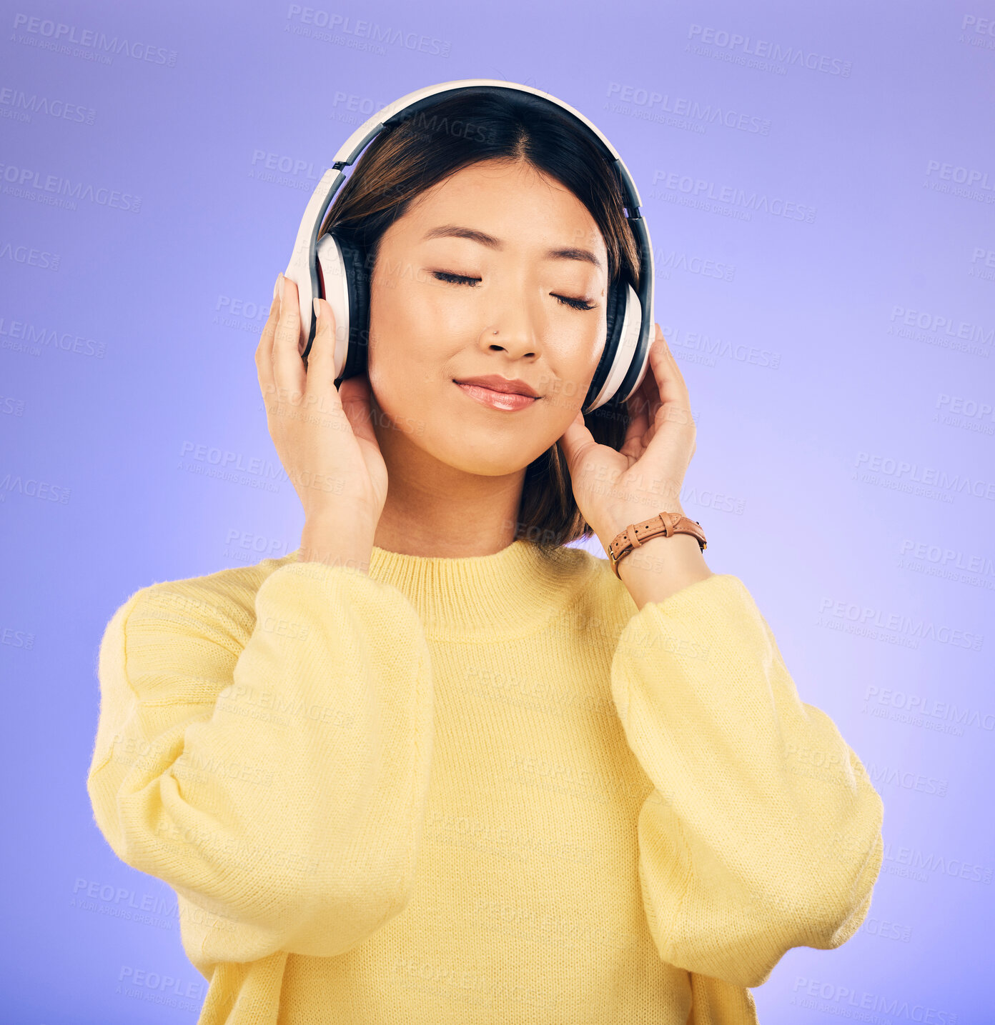 Buy stock photo Headphones, music and happy Asian woman relax in studio for streaming app, subscription and radio. Calm, podcast and isolated female person listening to audio, song and track on purple background