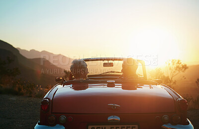 Buy stock photo Shot of a senior couple enjoying the sunset during a roadtrip