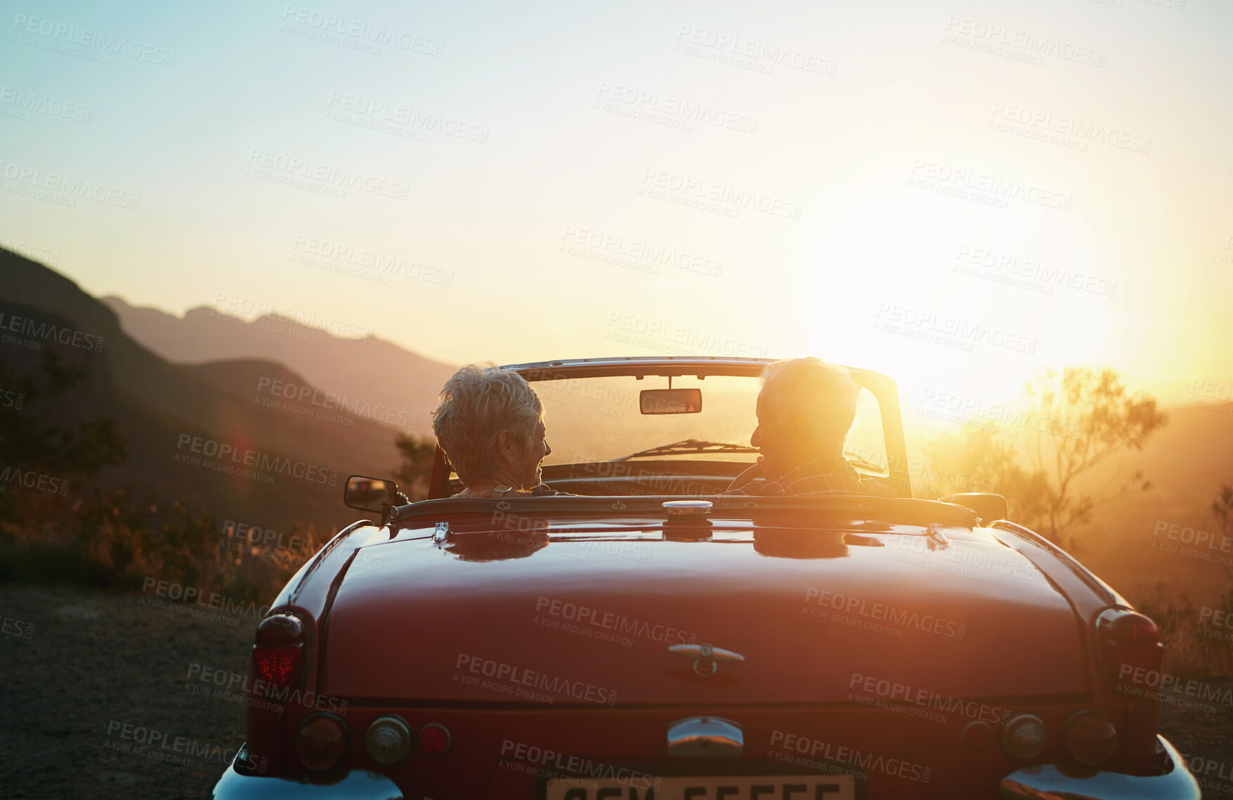 Buy stock photo Shot of a senior couple enjoying the sunset during a roadtrip