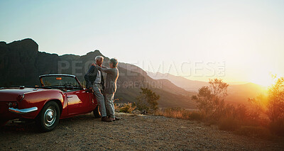 Buy stock photo Shot of an affectionate senior couple enjoying the sunset during a roadtrip