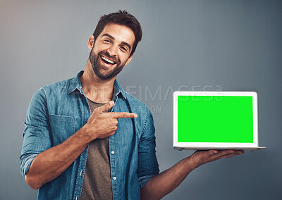 Buy stock photo Happy man, tablet and pointing to green screen for advertising against a grey studio background. Portrait of male person smiling and showing technology display, chromakey or mockup for advertisement