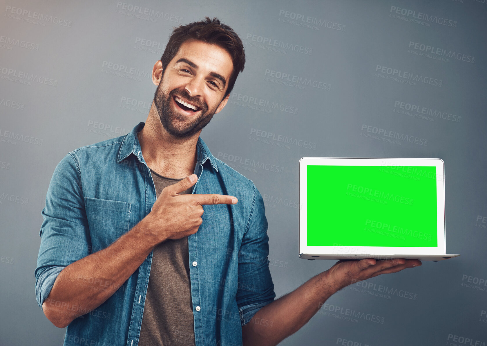 Buy stock photo Happy man, tablet and pointing to green screen for advertising against a grey studio background. Portrait of male person smiling and showing technology display, chromakey or mockup for advertisement