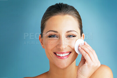 Buy stock photo Dermatology, portrait and happy woman with cotton pad on face, skincare and makeup cleaning product. Cosmetics, skin care and wellness for model with beauty, detox and facial glow on blue background.
