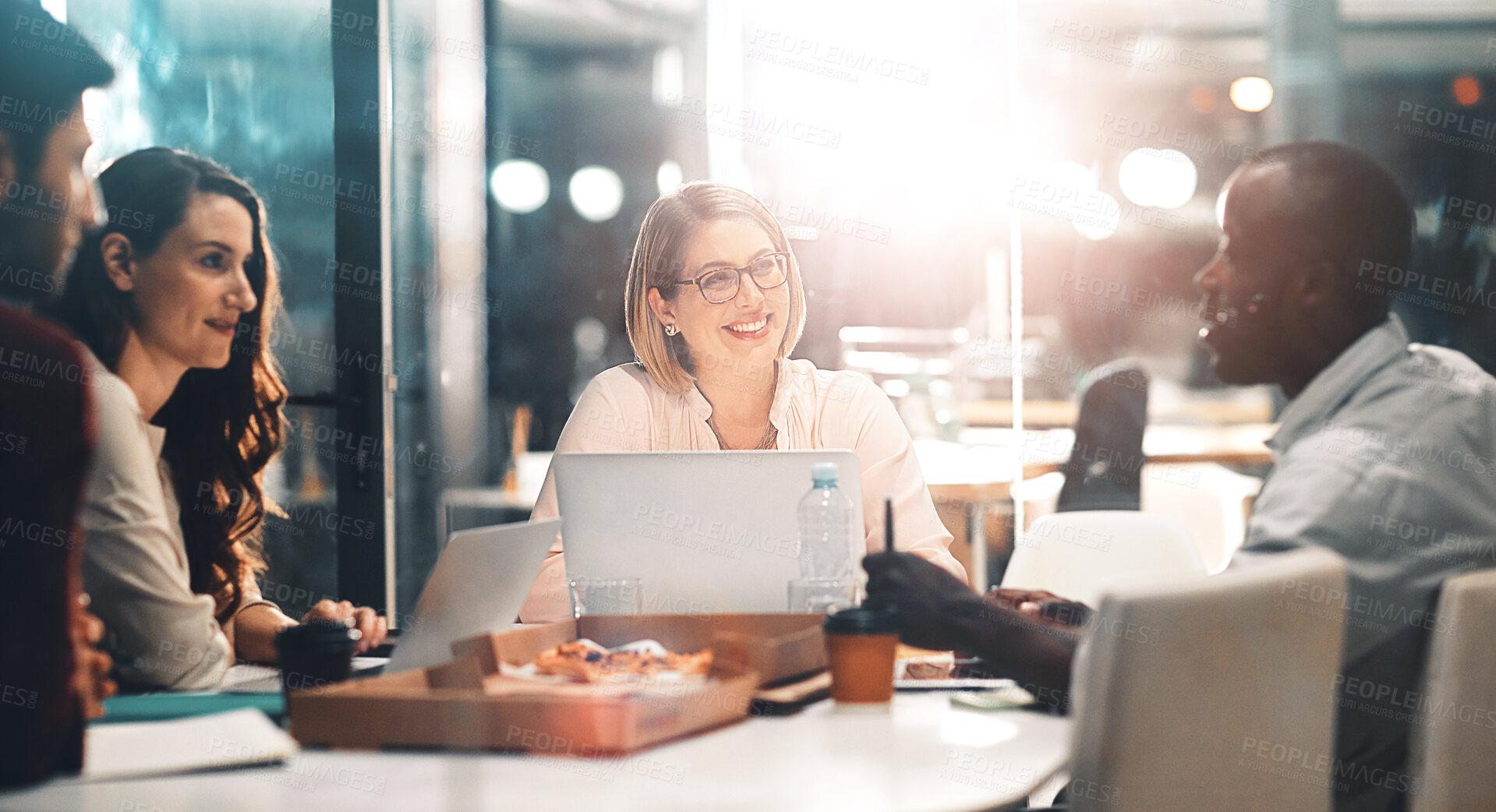 Buy stock photo Teamwork, late night and business people at workshop table with ideas, laptop and pizza at creative agency. Proposal, overtime and diversity, dinner for men and women brainstorming at startup project