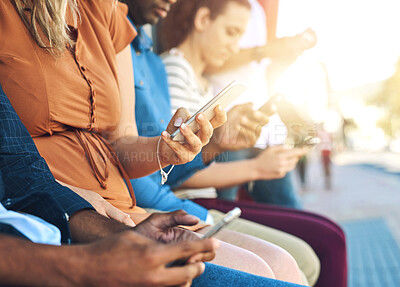 Buy stock photo Shot of a group unrecognizable people using their phones outside during the day