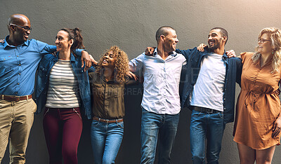 Buy stock photo Shot of a group cheerful friends holding each other while posing for a photo outside of a building