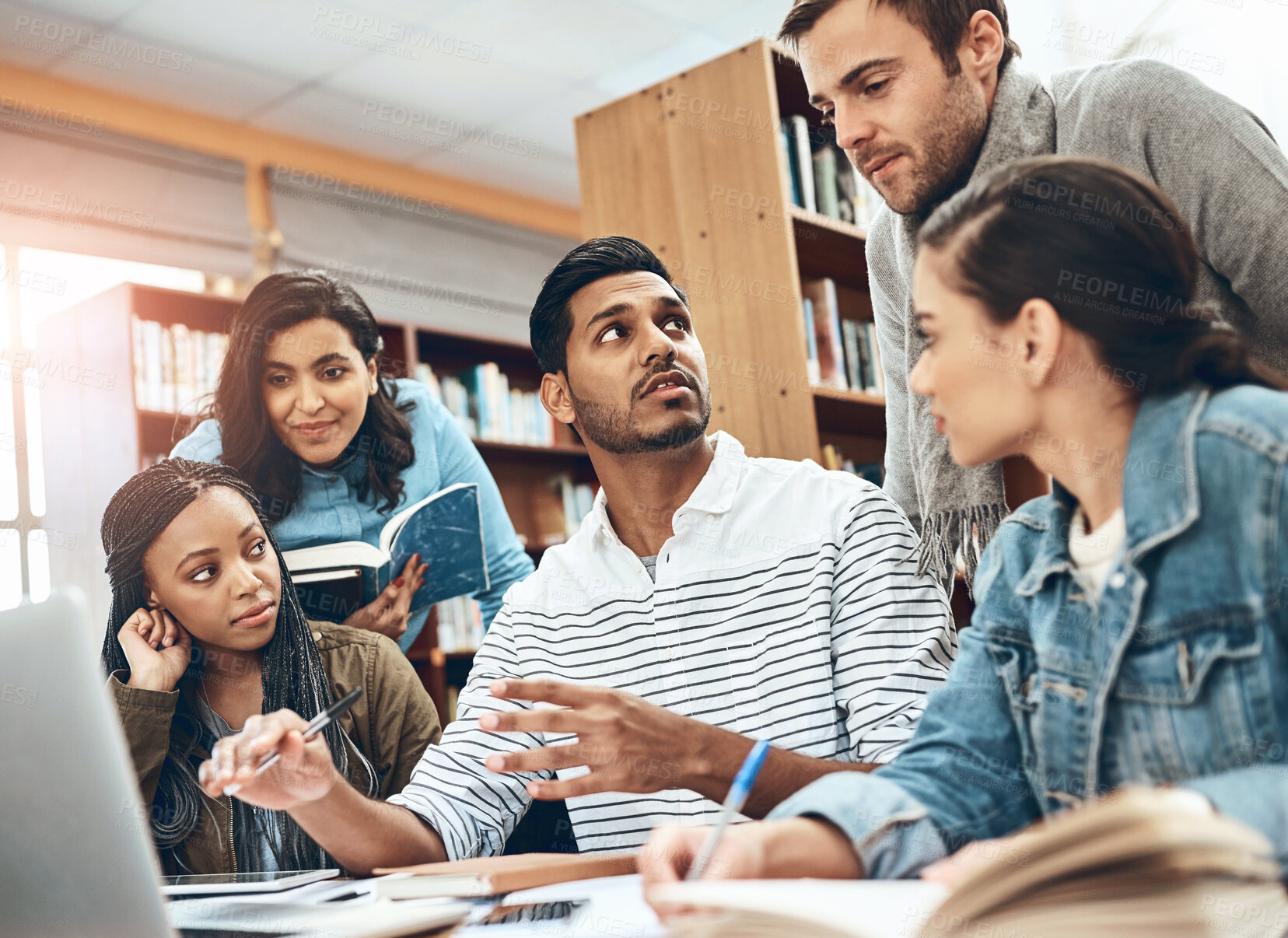 Buy stock photo Education, talking and students studying in a library for a group project, teamwork and learning. Diversity, laptop and friends speaking about university notes, knowledge and planning research