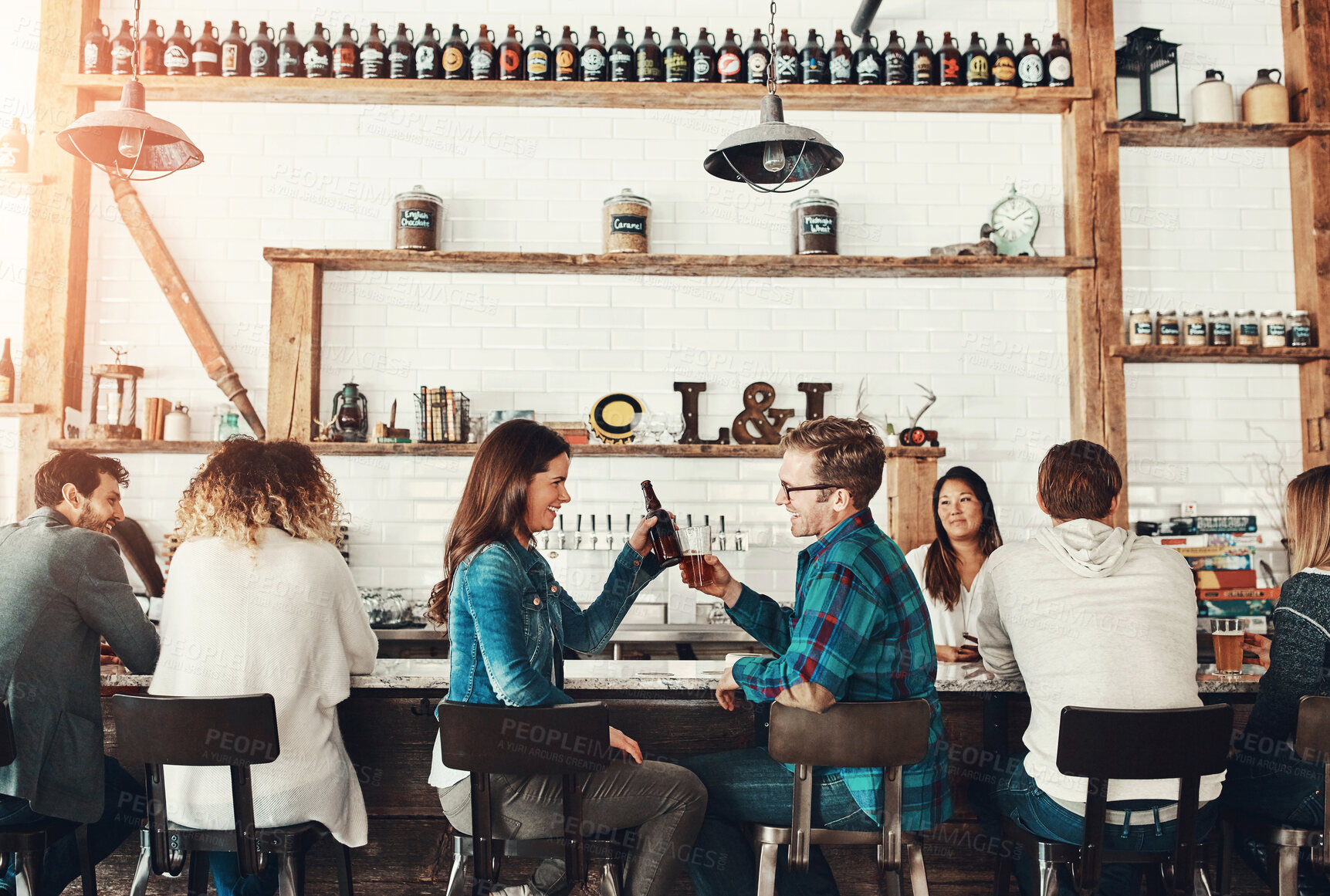 Buy stock photo Shot of young people enjoying a drink at a bar