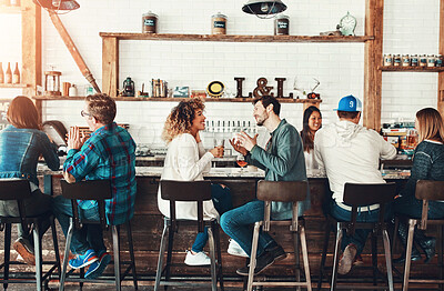 Buy stock photo Shot of young people enjoying a drink at a bar