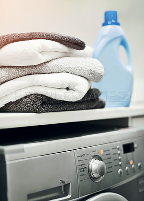 Buy stock photo Washing machine with stacked, folded towels and detergent on a countertop inside a scullery room at home. Clean clothes after washing, cleaning, drying. Using household equipment for hygiene.