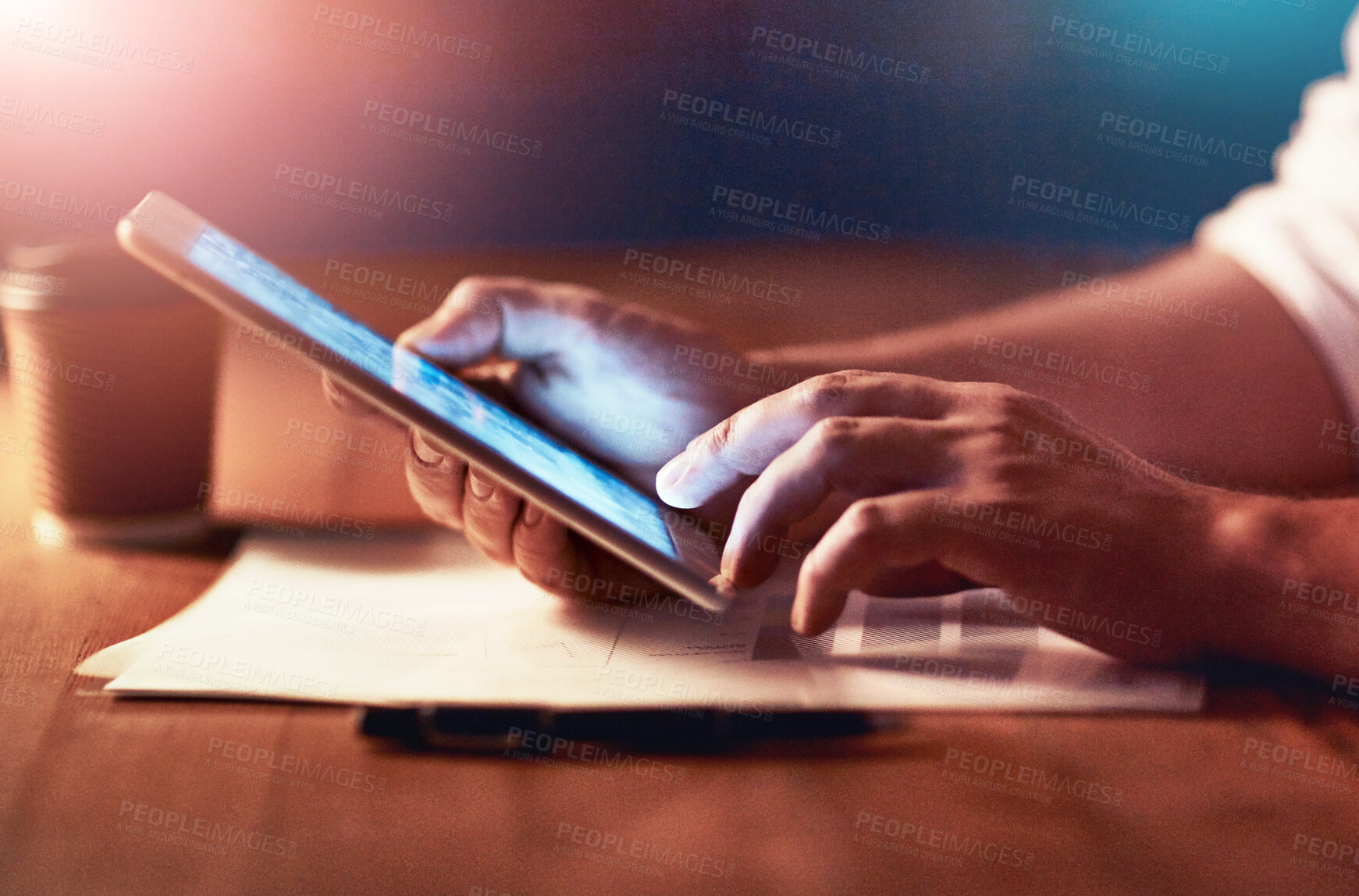 Buy stock photo Closeup of a persons hands holding and scrolling on a digital tablet planning late in the evening at night. Modern man working online with a touchscreen display device, at desk of workplace