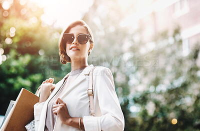 Buy stock photo Elegant woman holding shopping bags after a spending spree, retail therapy and buying clothes in a city. Trendy, stylish and fashionable lady purchasing gifts, presents and classy clothing downtown