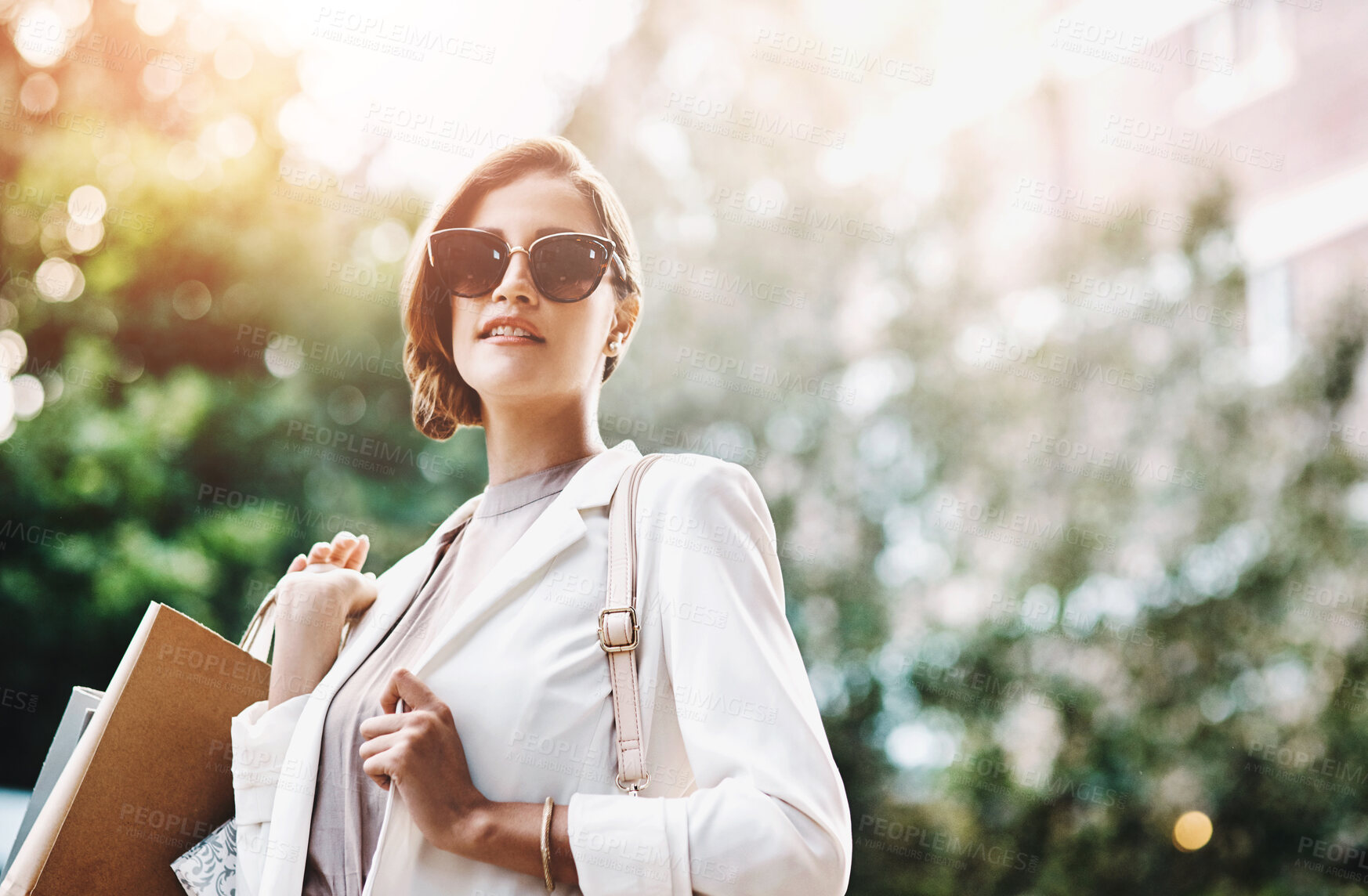 Buy stock photo Elegant woman holding shopping bags after a spending spree, retail therapy and buying clothes in a city. Trendy, stylish and fashionable lady purchasing gifts, presents and classy clothing downtown