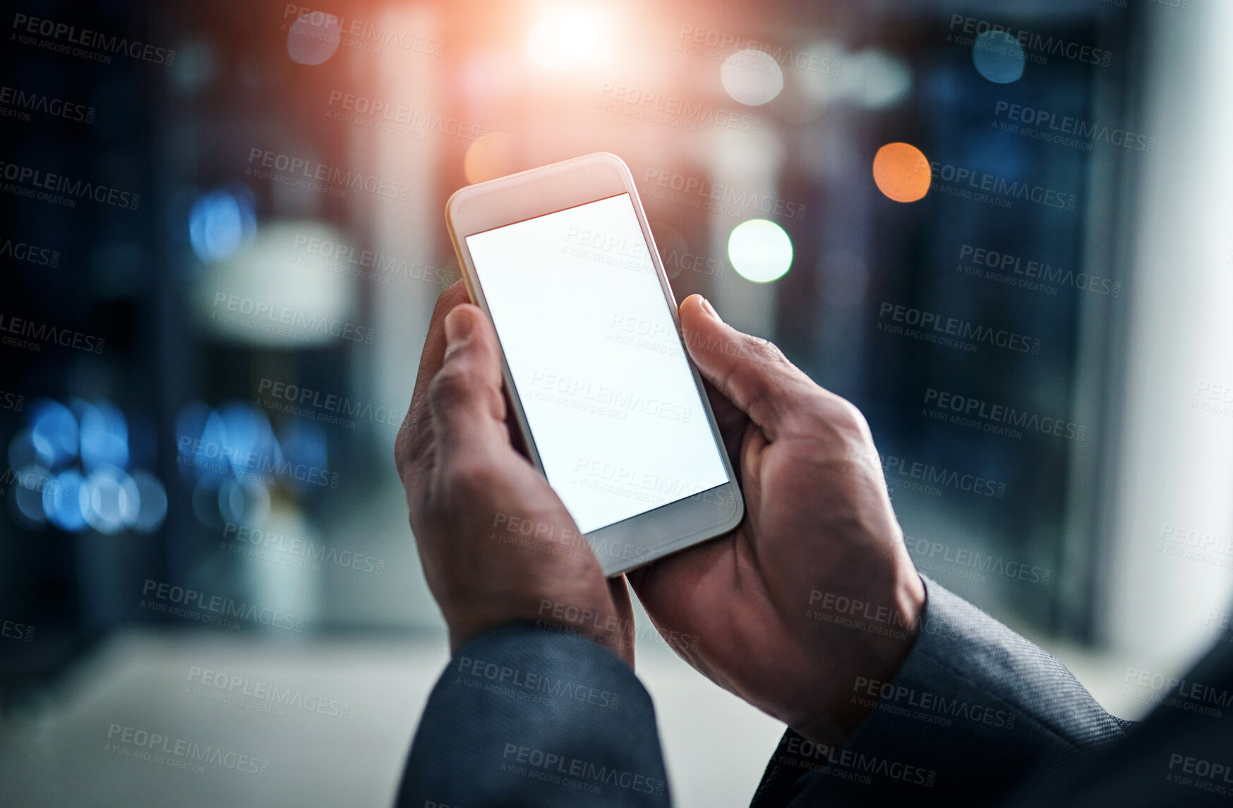 Buy stock photo Businessman hands holding phone with white screen template in modern office. Closeup businessperson reading text message on smartphone at night while working overtime at work