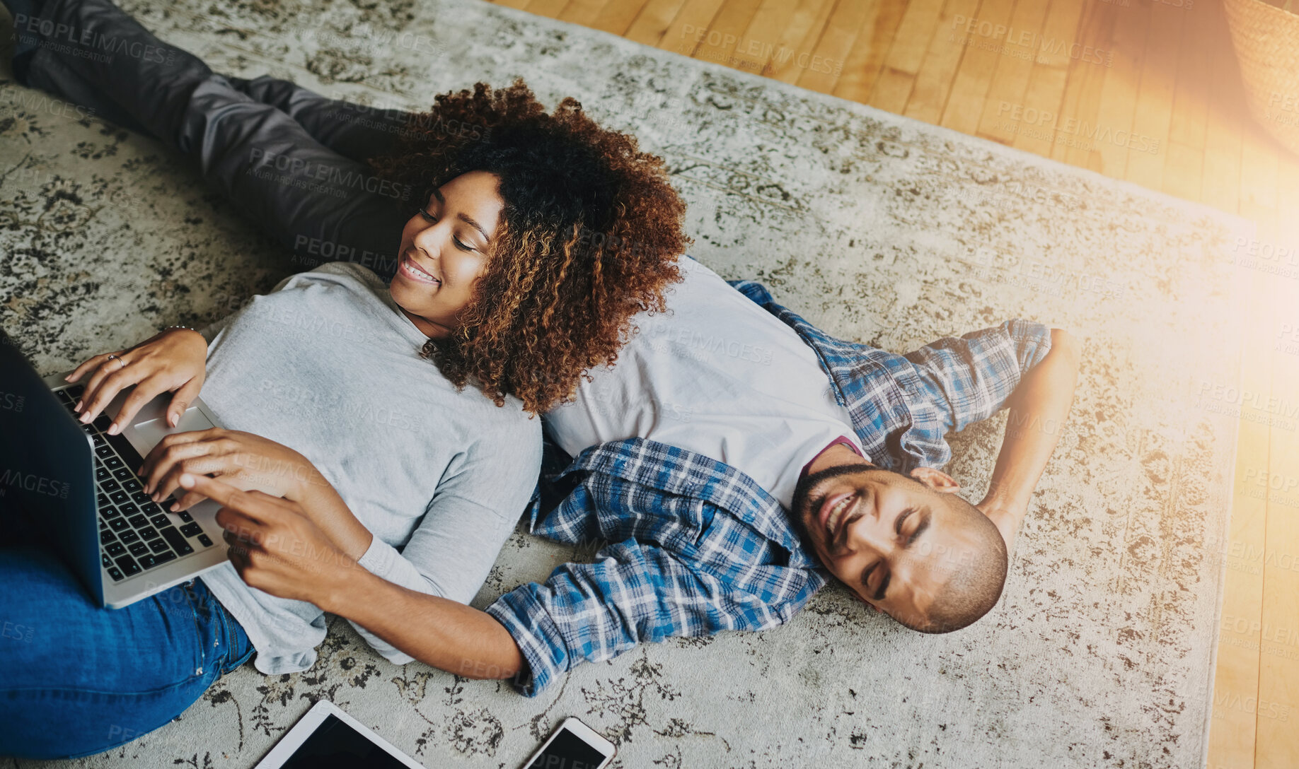 Buy stock photo Happy, relaxed and carefree couple bonding together on the living room floor at home. Loving, affectionate and smiling boyfriend and girlfriend relaxing, typing on a laptop and lying down from above