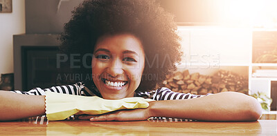 Buy stock photo Portrait of a cheerful young woman resting with her hands on a table while wearing yellow cleaning gloves at home during the day