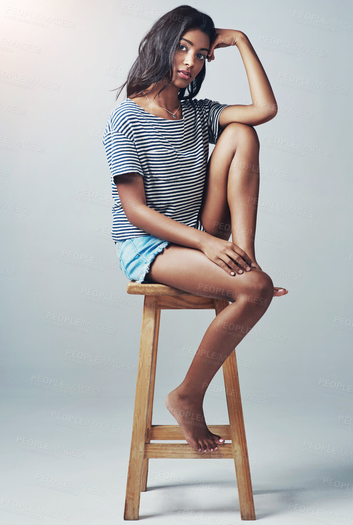 Buy stock photo Portrait, fashion and girl on wooden stool, relax and casual outfit on a grey studio background. Face, Indian person and model with stylish outfit and gen z with teenager on chair with break or rest