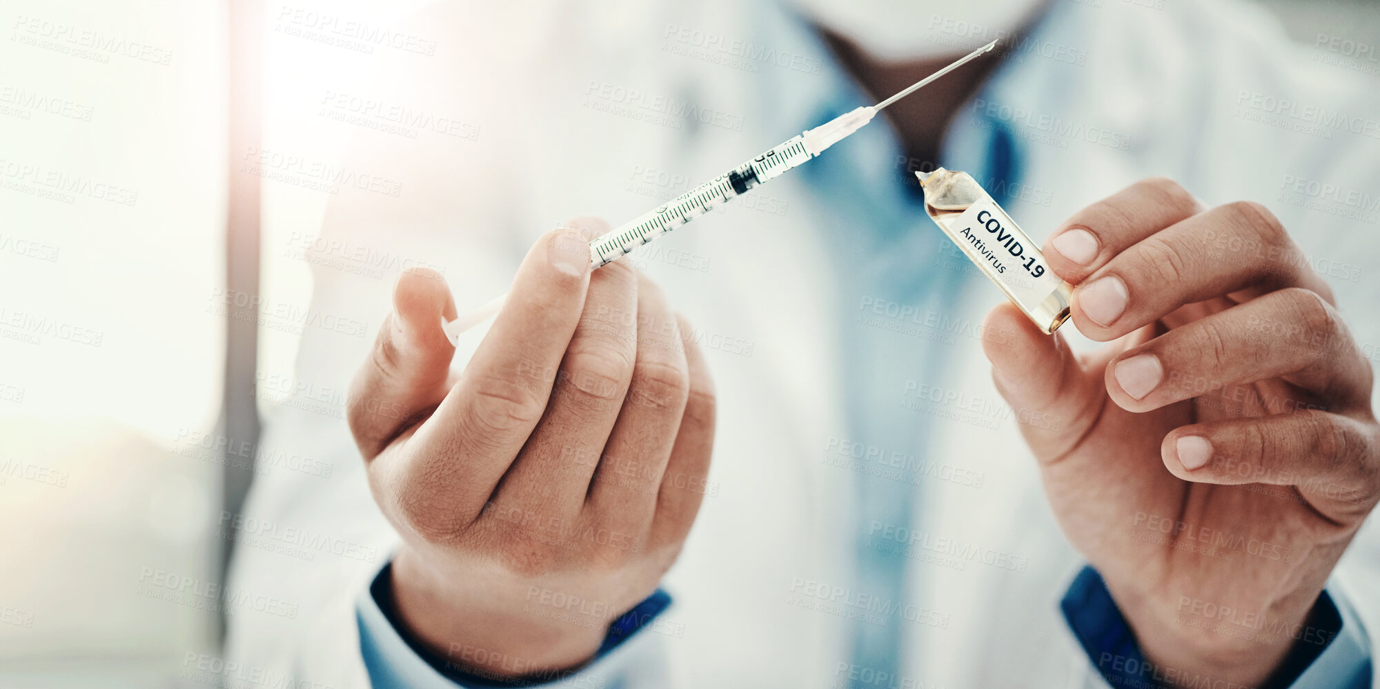 Buy stock photo Shot of a scientist extracting medication using a syringe from an ampoule with 2019-nCov on it