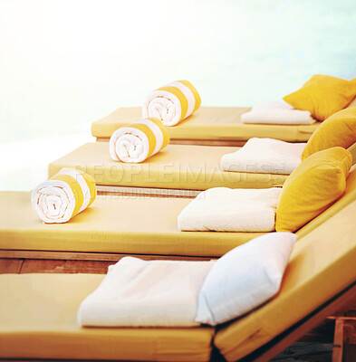 Buy stock photo Closeup row of yellow deckchairs in a line at a resort. When you need seating or a comfortable place to sit when on holiday or vacation by the pool. Towels on pillows on loungers outside at a villa