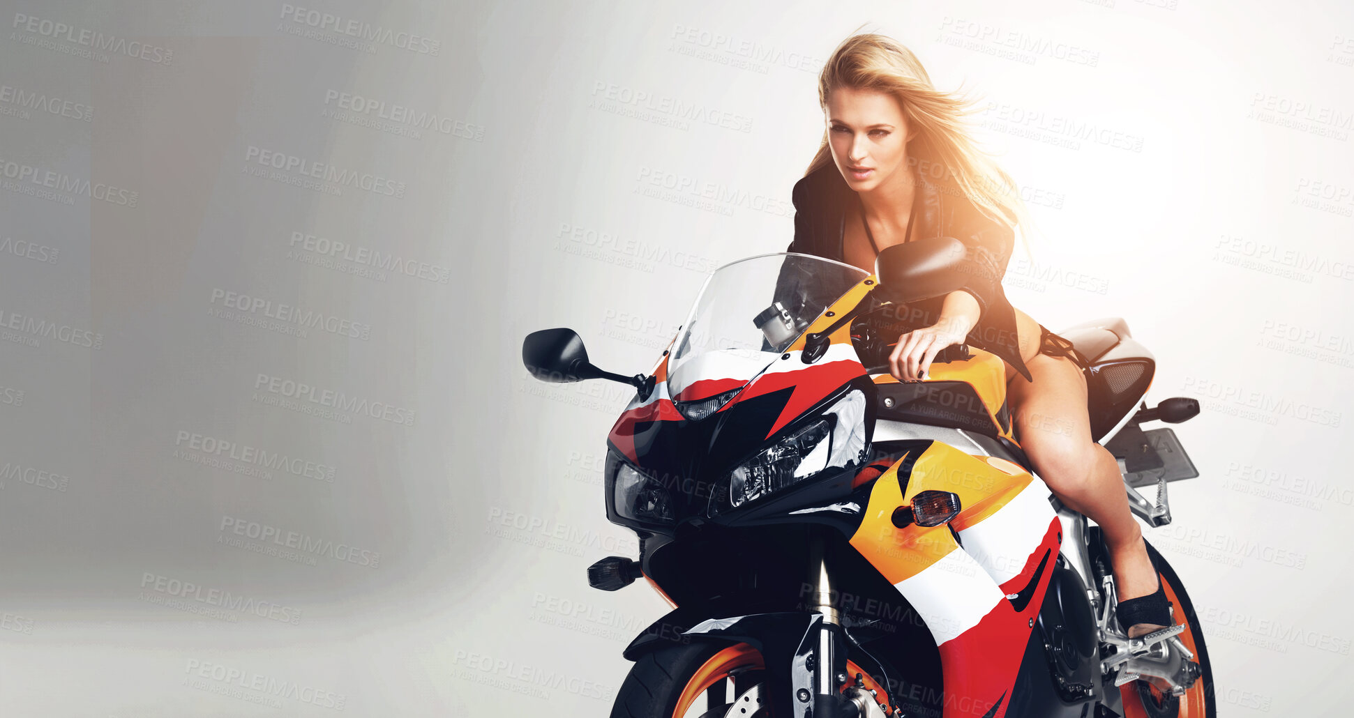 Buy stock photo Studio portrait of a sexy young woman in a leather jacket and bikini riding a motorbike