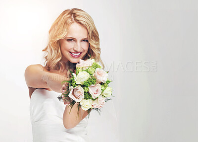 Buy stock photo Gorgeous young bride holding out her bouquet towards you - portrait